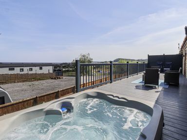 An outdoor area with a hot tub and chairs at Castle View in Scarborough