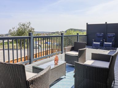 An outdoor patio with seating and a bottle of wine at Castle View in Scarborough