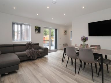 A living room with a sofa and dining area at Woodside in Scarborough