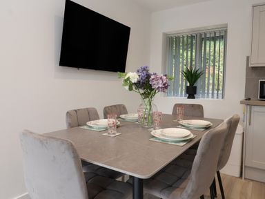 A dining room with a table set for six at Woodside in Scarborough