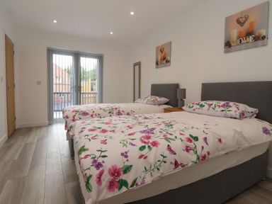 A bedroom with two beds and sliding doors at Woodside in Scarborough