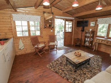 A living room with a table and chairs at The Lodge in 