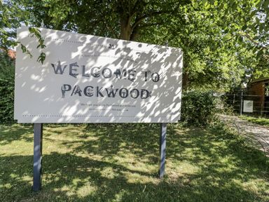 A welcome sign at Packwood with greenery and a pathway