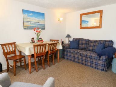 A dining room with table and chairs at Driftwood in Weymouth