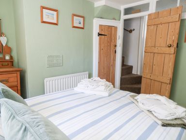 A bedroom with a bed and dresser at Driftwood in Weymouth