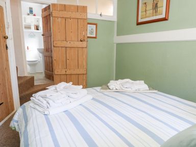 A bedroom with a bed and towels at Driftwood in Weymouth