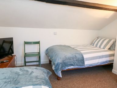 A bedroom with two beds and a television at Driftwood in Weymouth