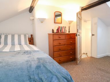 A bedroom with a bed and a dressing table at Driftwood in Weymouth