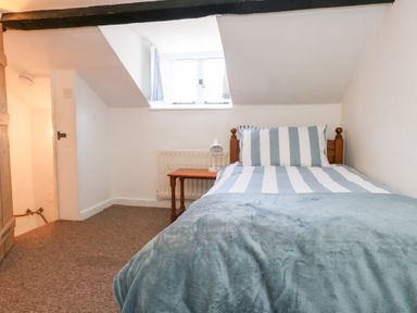 A bedroom with a bed and table at Driftwood in Weymouth