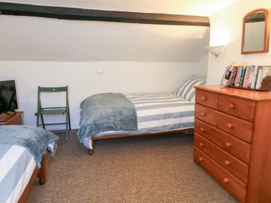 A bedroom with two beds and a dresser at Driftwood in Weymouth