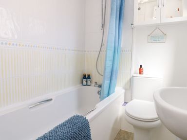 A bathroom with a bathtub and toilet at Driftwood in Weymouth