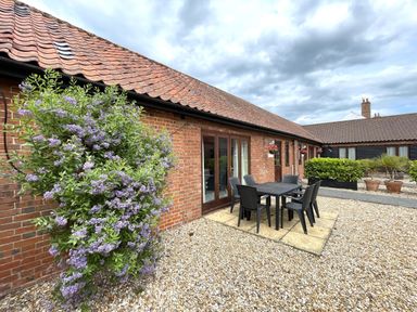 An outdoor area with a table and chairs at Beechwood in Wood Norton near Foulsham