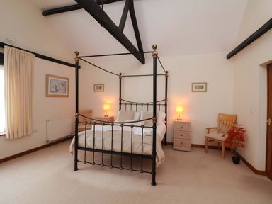 A bedroom featuring a four-poster bed and furniture at Beechwood in Wood Norton