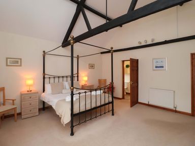 A bedroom with a four-poster bed and furniture at Beechwood in Wood Norton