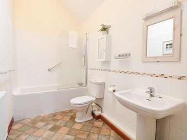 A bathroom with a bathtub, toilet, and sink at Willow in Wood Norton near Foulsham