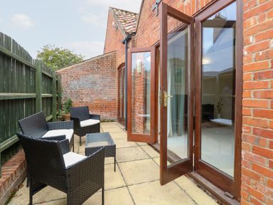 An outdoor seating area with chairs and a table at Willow Wood Norton near Foulsham