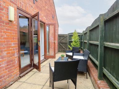 An outdoor seating area with a table and chairs at Willow in Wood Norton near Foulsham