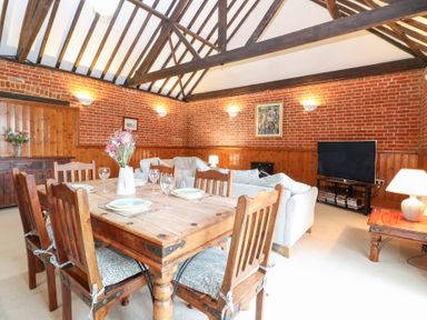A dining room with a table and chairs at Pear Tree in Wood Norton