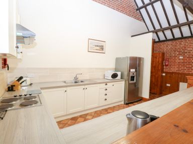 A kitchen with a sink and fridge at Pear Tree in Wood Norton