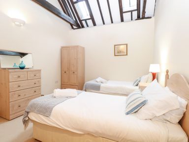 A bedroom with two beds and a dresser at Pear Tree in Wood Norton
