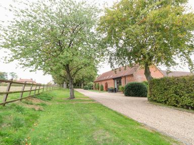 An outdoor view with trees and a gravel path at Pear Tree in Wood Norton
