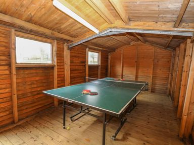 A wooden room with a ping pong table and paddles at Holly Berry in Wood Norton near Foulsham