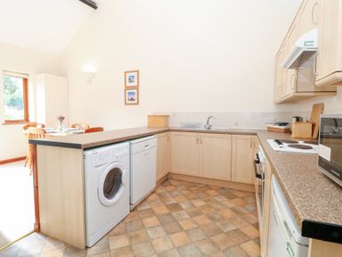 A kitchen with appliances and dining area at Holly Berry in Wood Norton near Foulsham