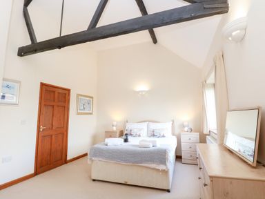 A bedroom with a bed and bedside tables at Holly Berry Wood Norton near Foulsham