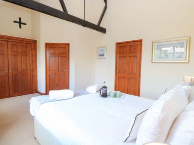 A bedroom with a bed and two doors at Holly Berry Wood Norton near Foulsham