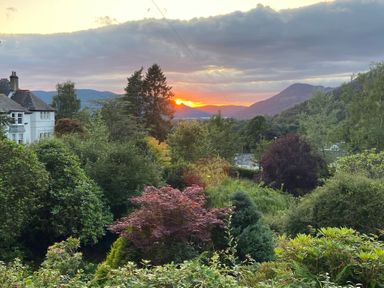 A sunset view with trees and a house at High Cross in Keswick