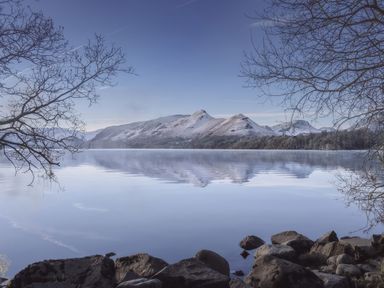 A landscape view of mountains reflecting on water at High Cross in Keswick