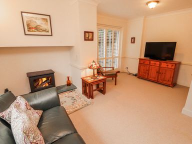 A living room with a fireplace and television at High Cross in Keswick