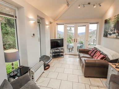 A snug with a sofa and television at High Cross in Keswick