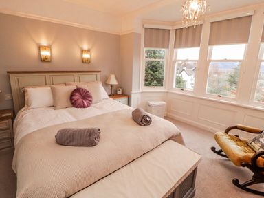 A bedroom with a bed and windows at High Cross in Keswick