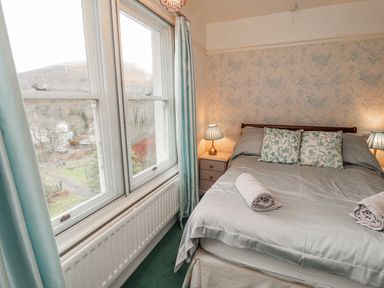 A bedroom with a bed and windows at High Cross in Keswick