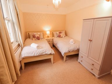 A bedroom with two single beds and a wardrobe at High Cross in Keswick