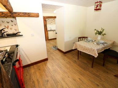 A kitchen with a dining table and stove at Dolcoed Manordeilo near Llangadog