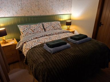 A bedroom with a bed and bedside table at Dolcoed in Llandeilo
