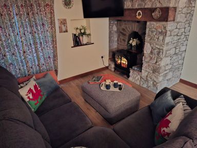 A living room with a sofa and a fireplace at Dolcoed in Llandeilo
