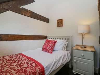 A bedroom with a single bed beside a nightstand with a lamp at White Haywood Farmhouse & Barn in Craswall