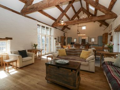 A living room with wooden beams sofas tables and dining area at White Haywood Farmhouse & Barn in Craswall