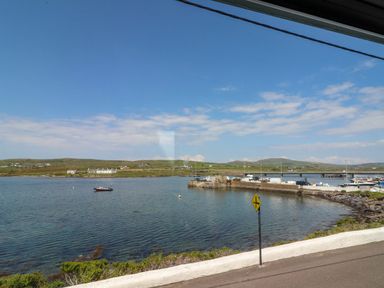 A coastal view with water and boats at O'Conells Portmagee