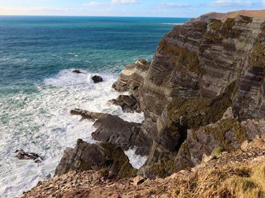 A coastal view of cliffs and waves at O'Conells Portmagee