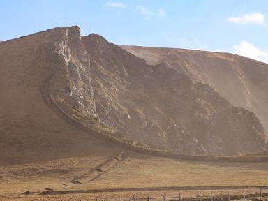 A cliff with a slope and grass at O'Conells in Portmagee