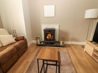A living room with a sofa, coffee table, and fireplace at O'Connell's Lodge, Portmagee, County Kerry