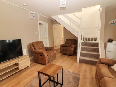 A living room with a TV and seating area at O'Connell's Lodge, Portmagee, County Kerry