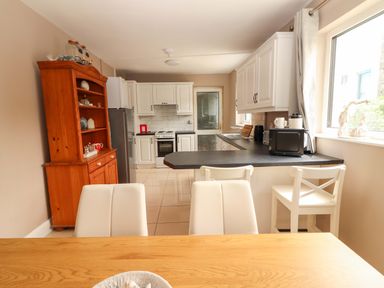 A kitchen with a dining table and appliances at O'Connell's Lodge in Portmagee, County Kerry