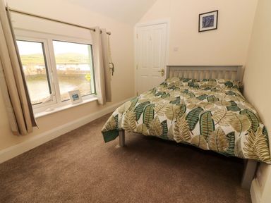 A bedroom with a bed and window at O'Connell's Lodge in Portmagee, County Kerry