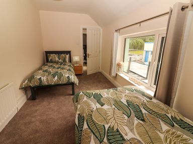 A bedroom with two beds and a window at O'Connell's Lodge in Portmagee, County Kerry