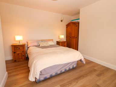 A bedroom with a bed and wooden furniture at O'Connell's Lodge, Portmagee, County Kerry
